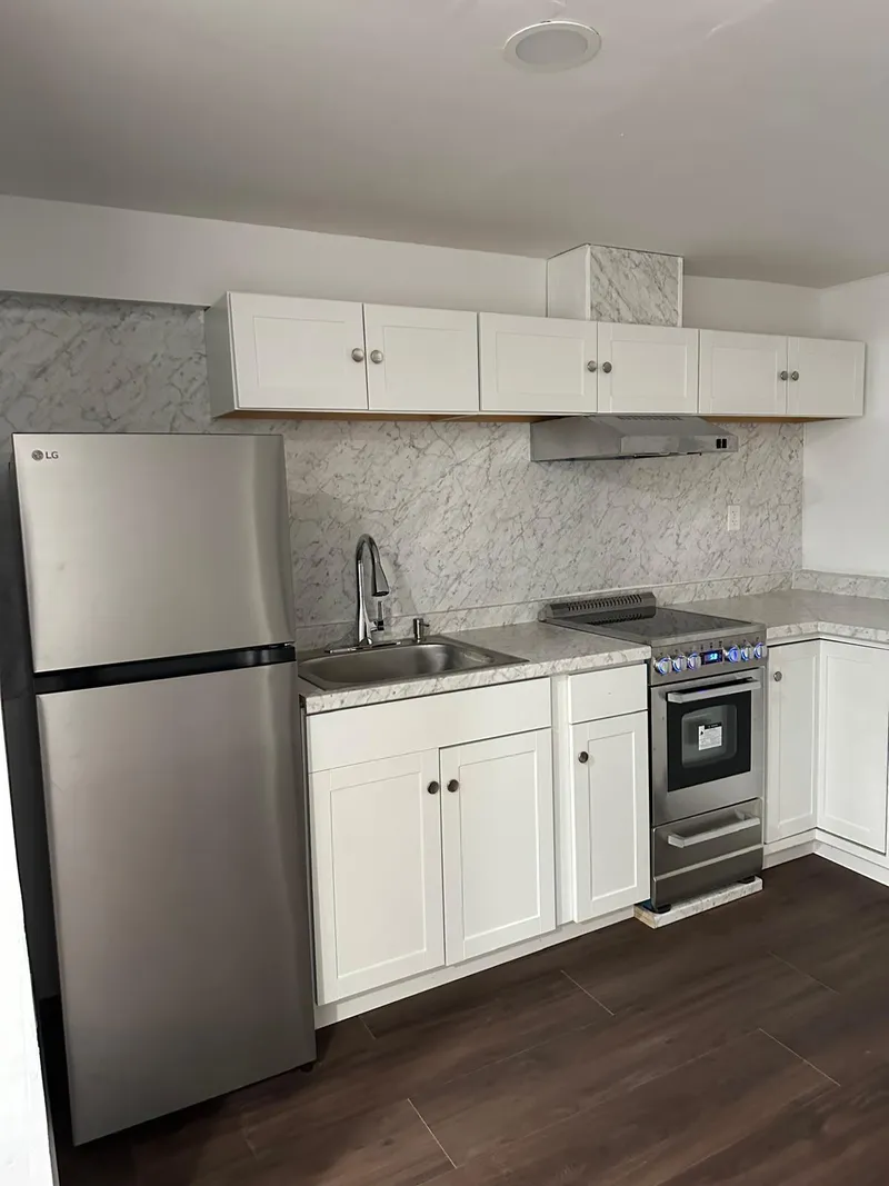 Full kitchen renovation with new cabinets, flooring, countertops, and lighting.